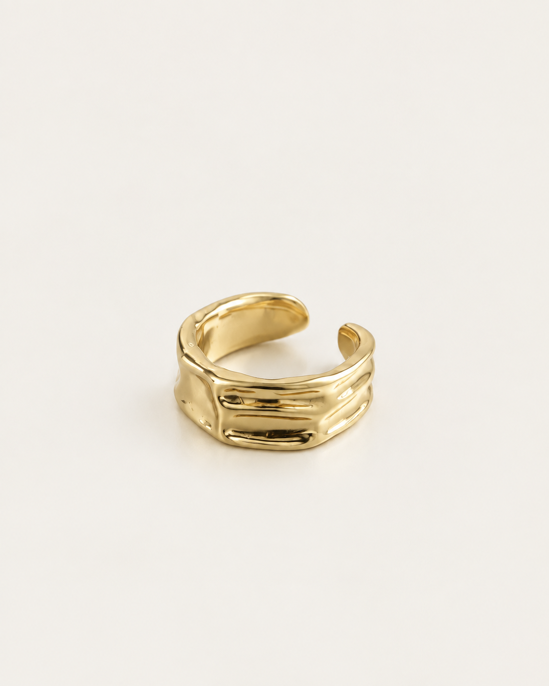 Gold-tone open band ring with a folded surface, rear angle showing the open band.