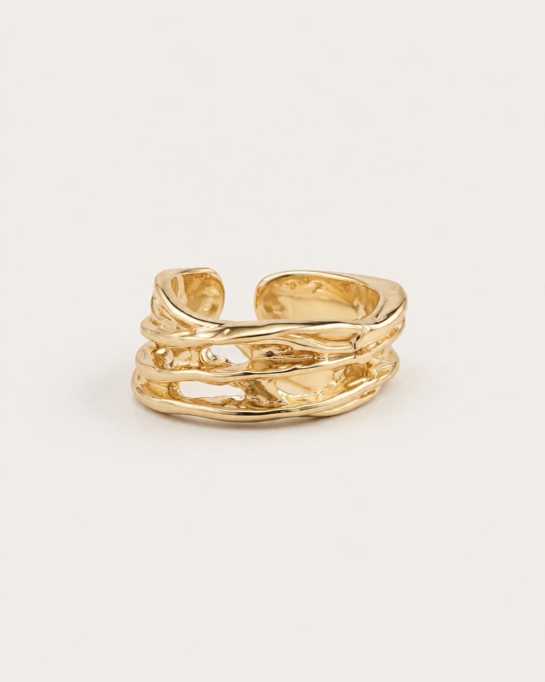 Gold-tone open ring with raised rails and irregular cutouts, front view.