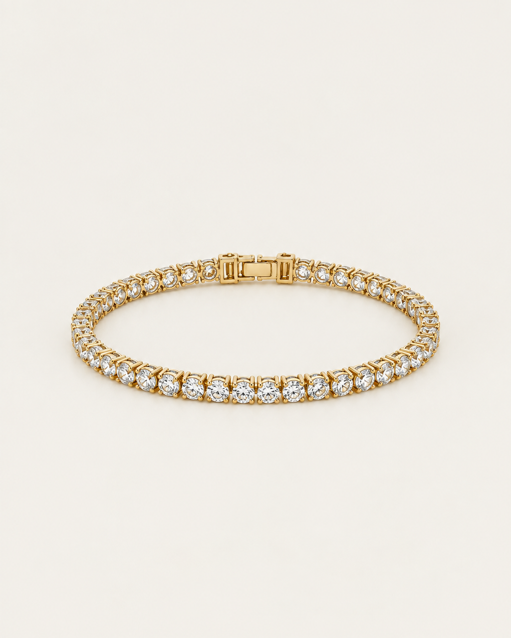 Gold-tone tennis bracelet with a continuous row of clear stone accents, laid out with the clasp visible.
