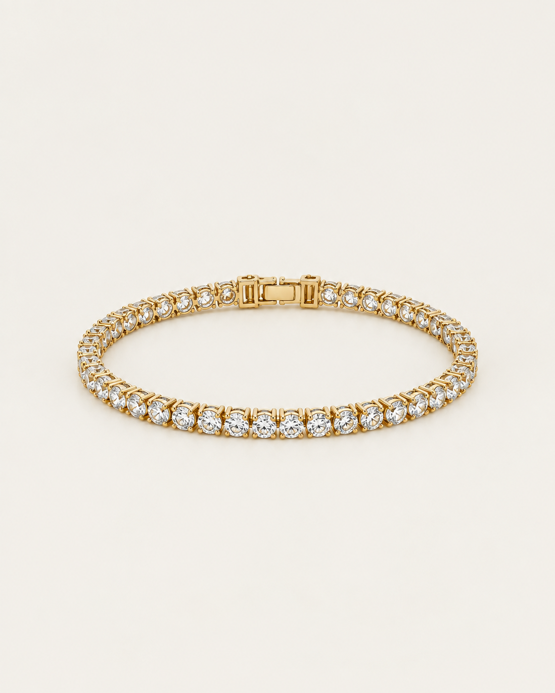 Gold-tone tennis bracelet with a continuous row of clear stone accents, laid out with the clasp visible.