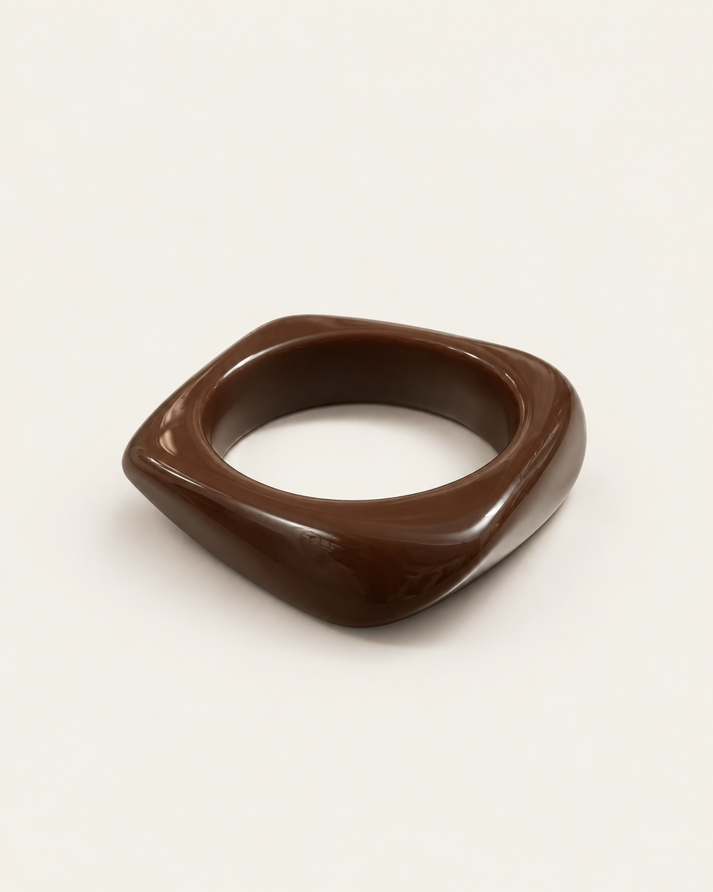 Chunky dark-brown bangle with an angular contour, overhead view showing the opening.