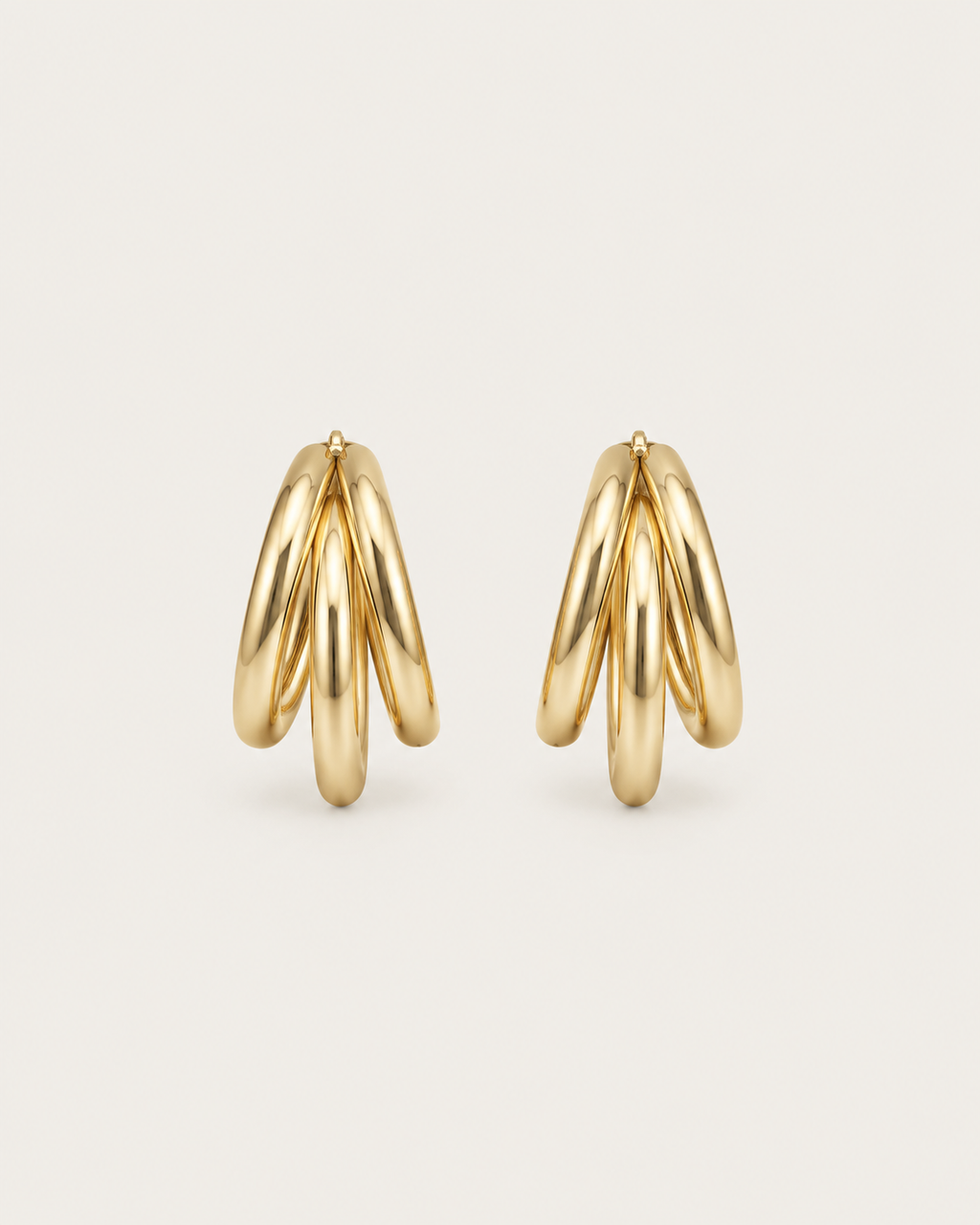 Pair of gold-tone hoop earrings with three overlapping strands, side view showing the layered strands.