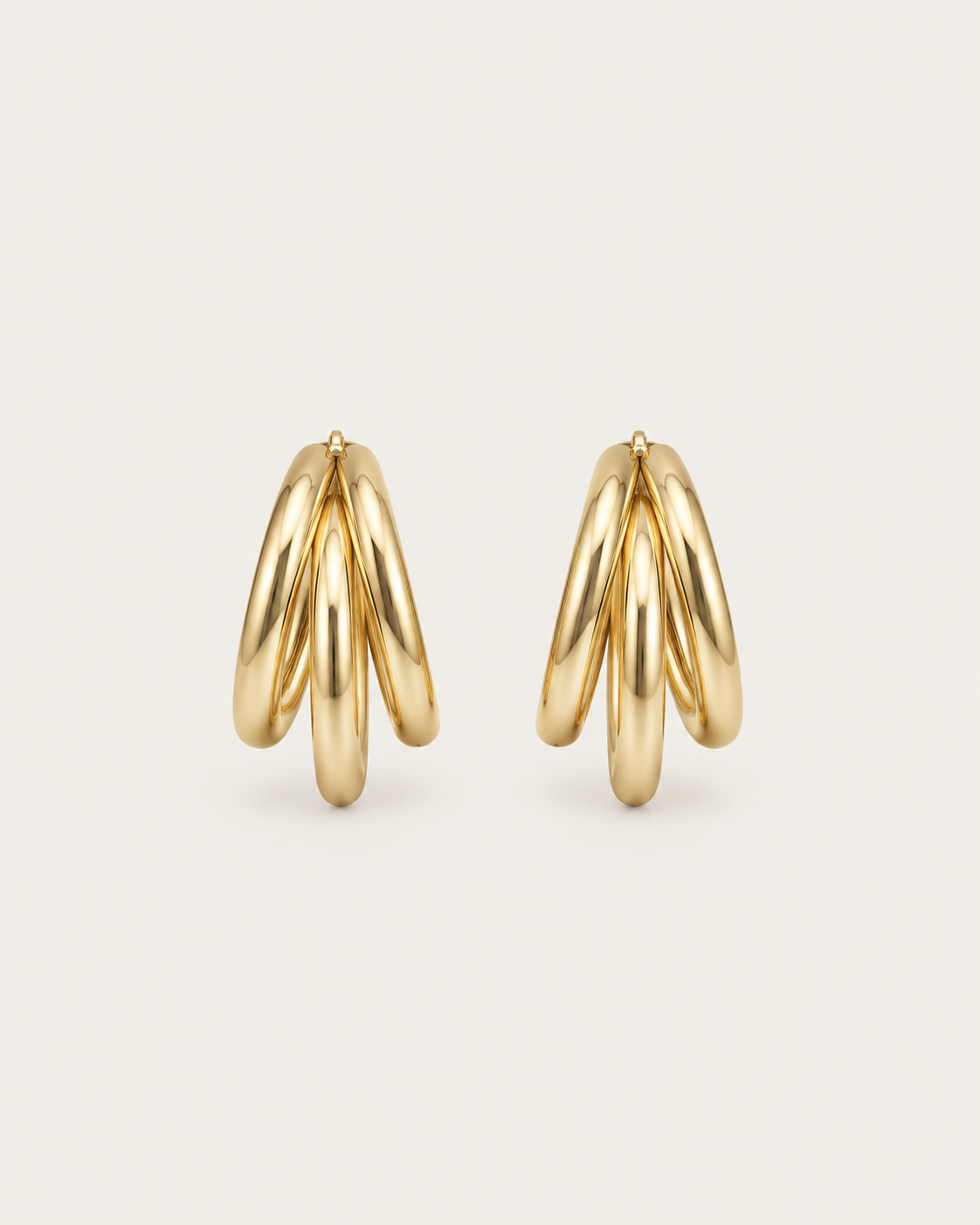 Pair of gold-tone hoop earrings with three overlapping strands, side view showing the layered strands.