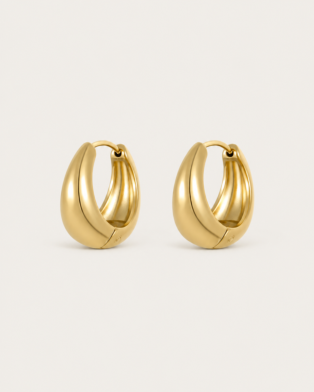 Pair of chunky gold-tone teardrop-shaped hoop earrings, shown together.