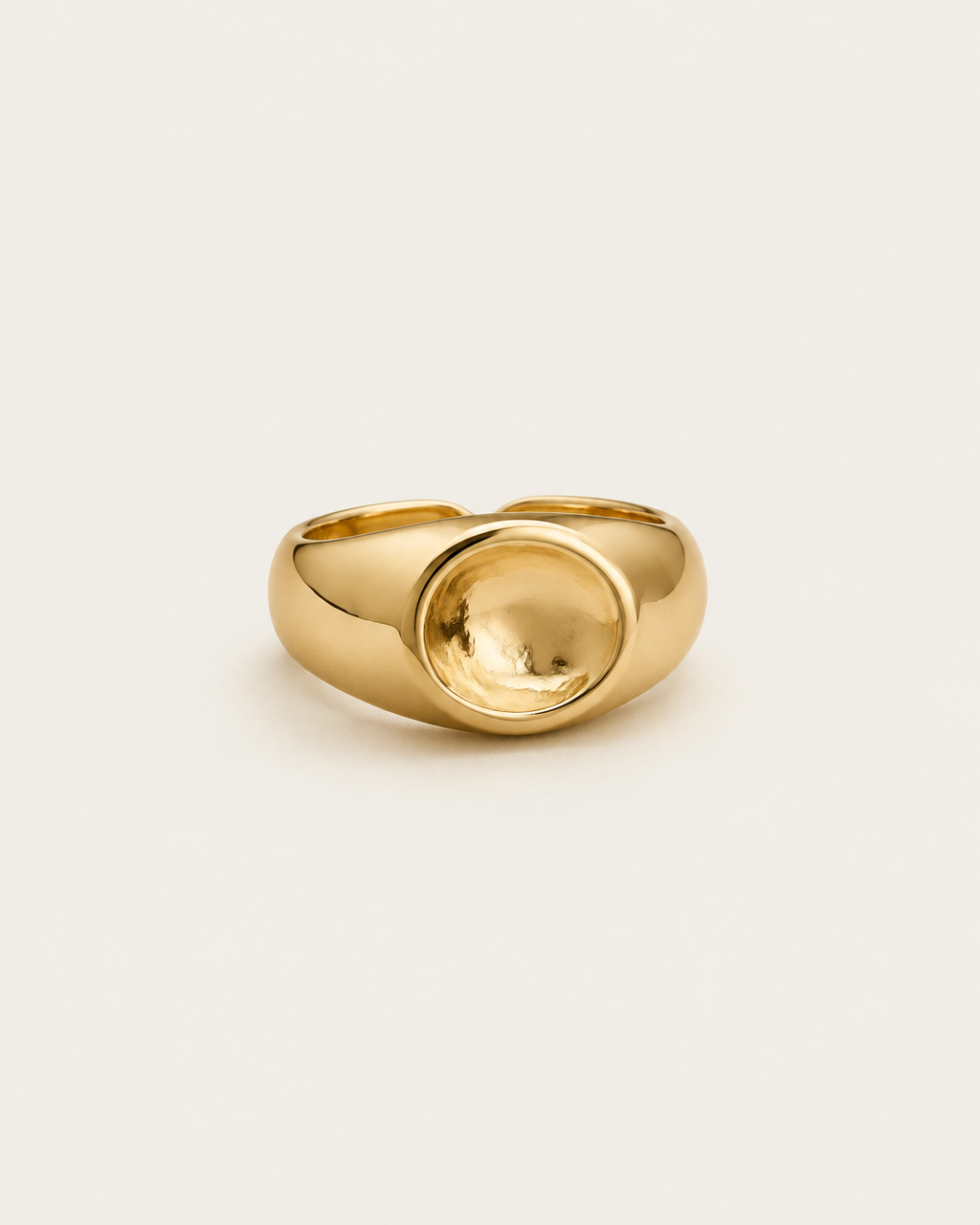 Gold-tone dome ring with a concave circular centre, front view.