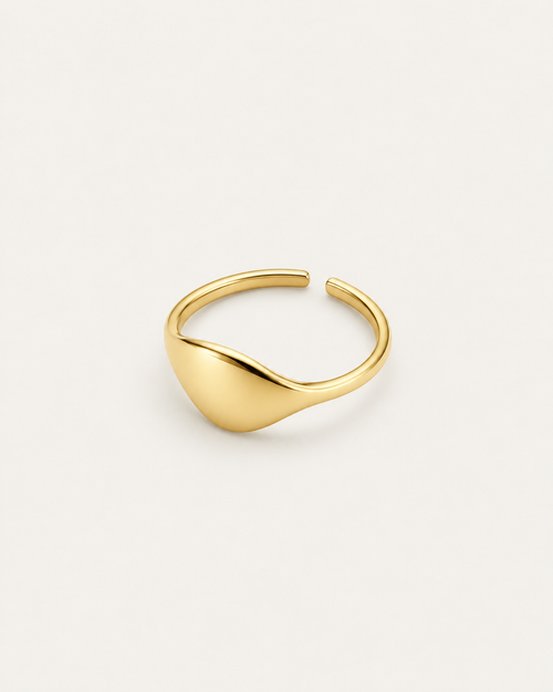 Gold-tone ring with an asymmetric domed front, angled view showing the open back.
