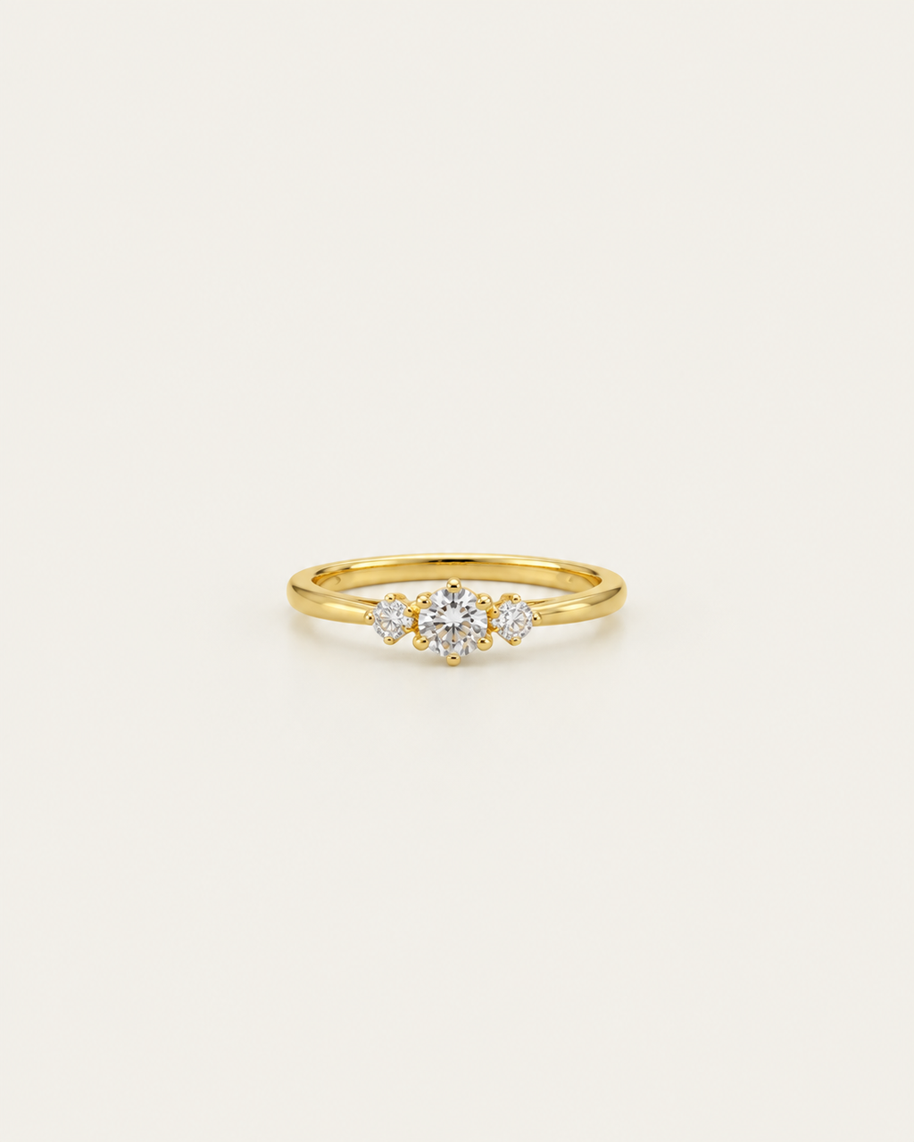 Gold-tone band ring with a central three-stone cluster, front view.