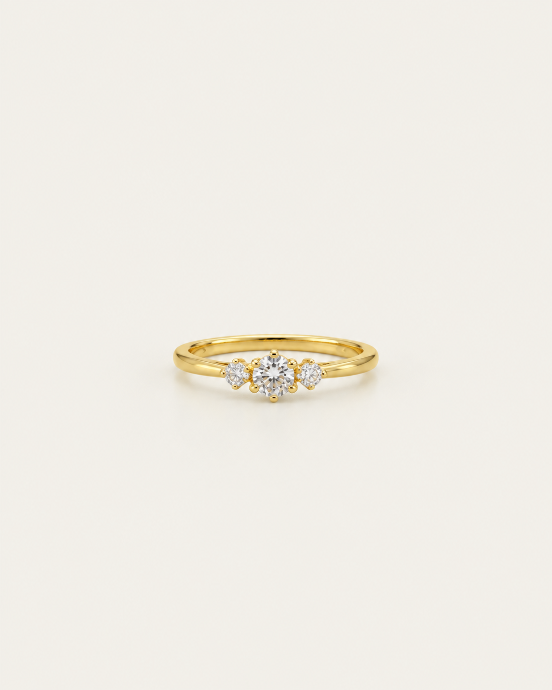 Gold-tone band ring with a central three-stone cluster, front view.