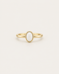 Slim gold-tone ring with a white oval bezel accent, front view.