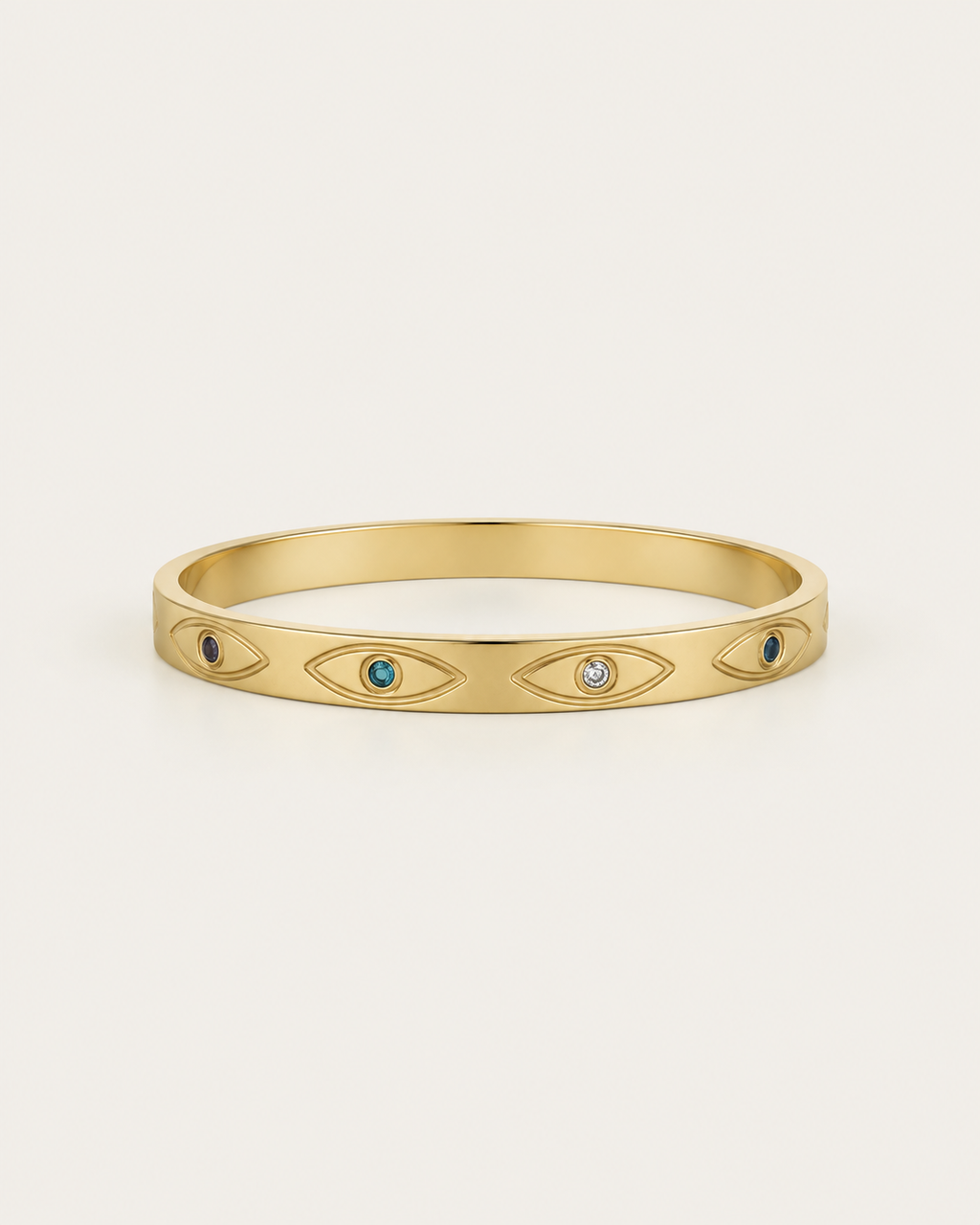 Gold-tone bangle with eye motifs and coloured centres, front view.
