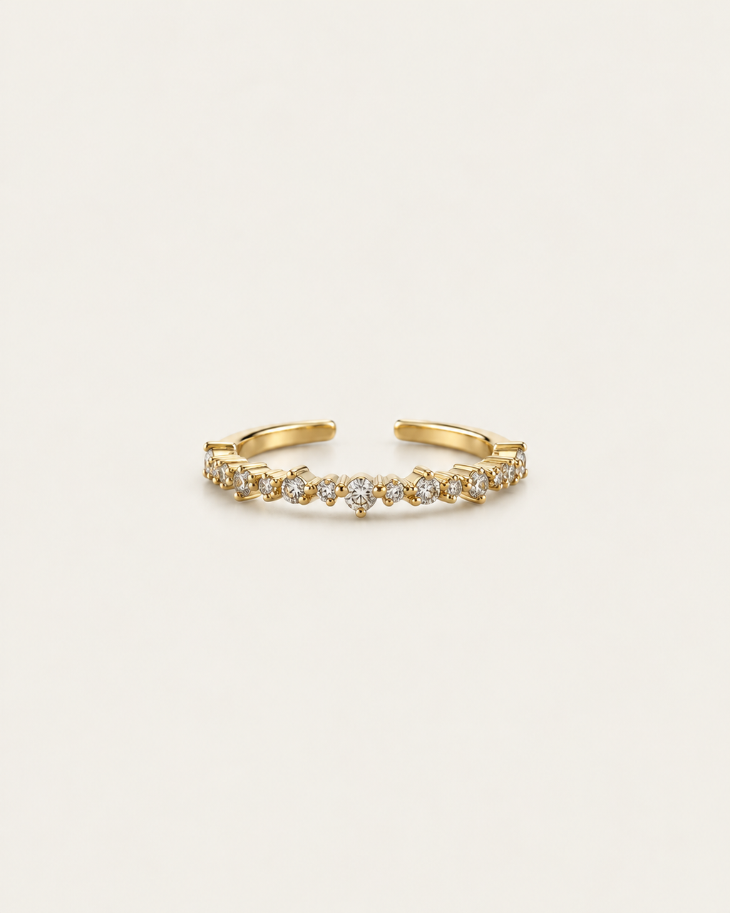 Gold-tone band ring with a row of clear stone accents, front view.