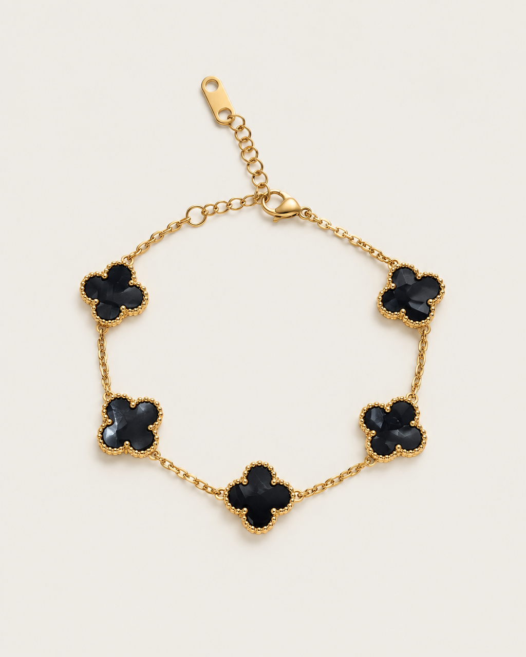 Chain bracelet with five dark-inlay clover stations, laid out on its own.