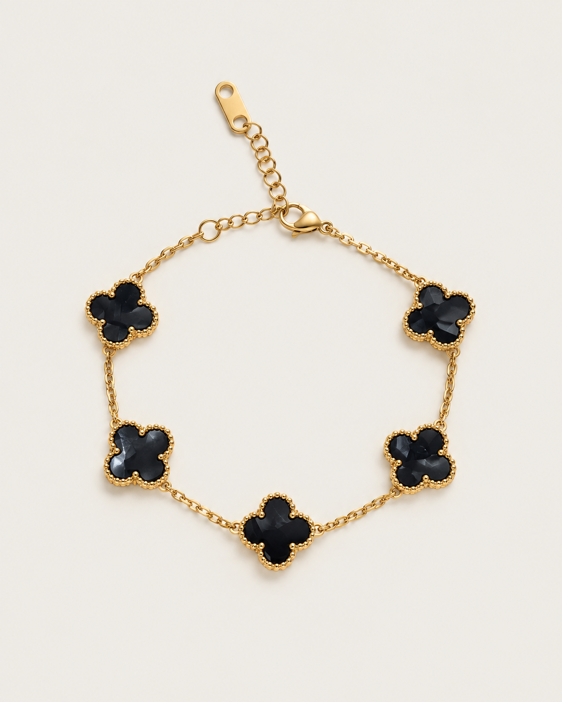 Chain bracelet with five dark-inlay clover stations, laid out on its own.