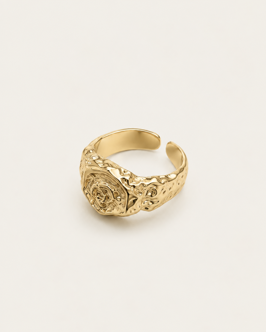 Gold-tone signet ring with an irregular molten-like texture, angled view showing the open back.