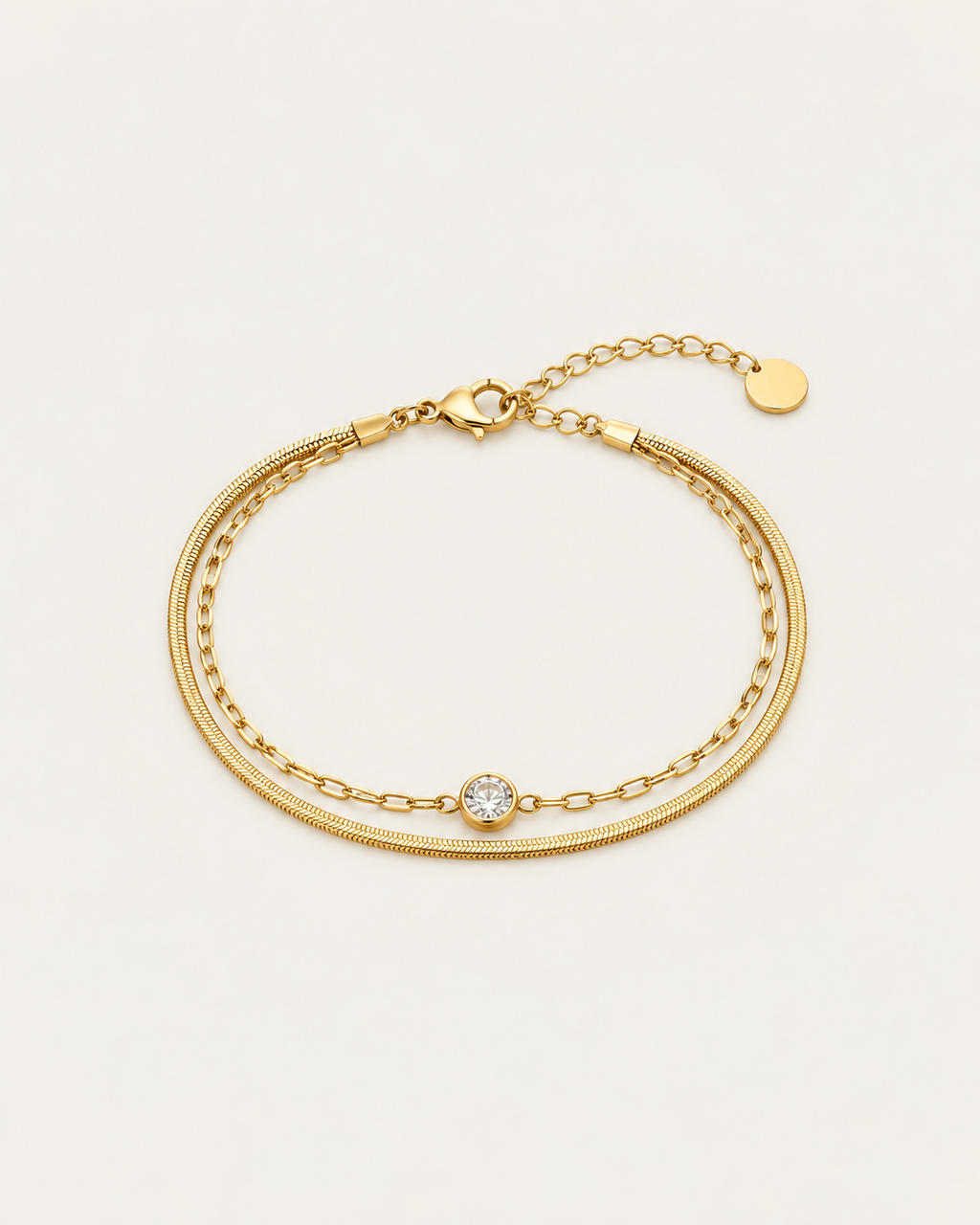 Gold-tone double-chain bracelet with a central stone accent, laid out with an extension chain.