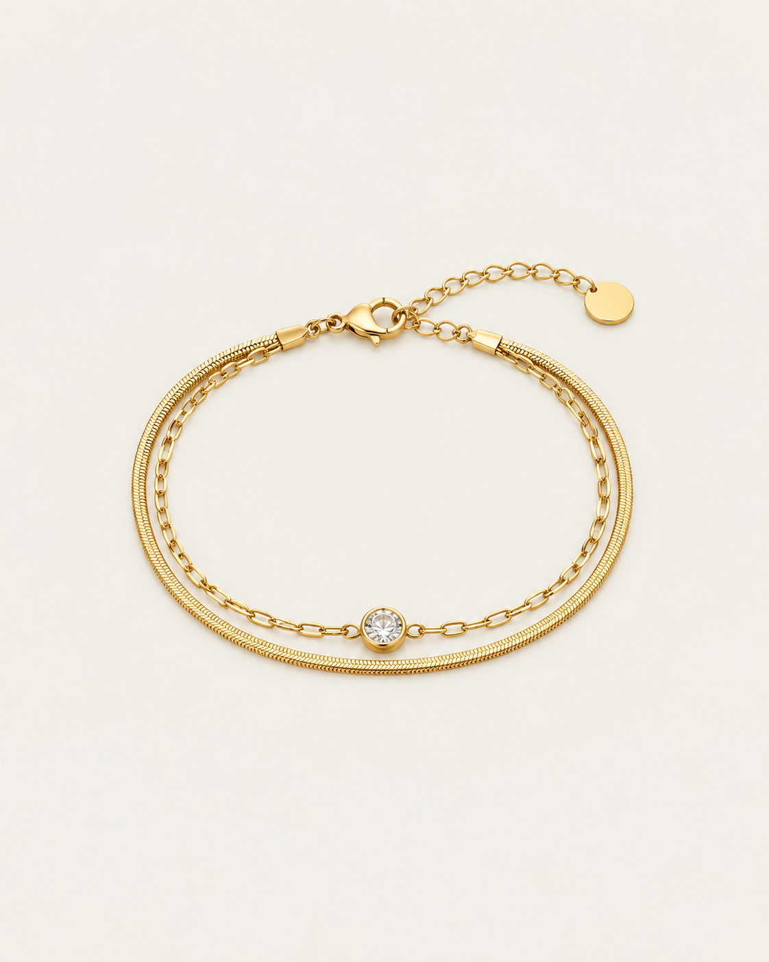Gold-tone double-chain bracelet with a central stone accent, laid out with an extension chain.