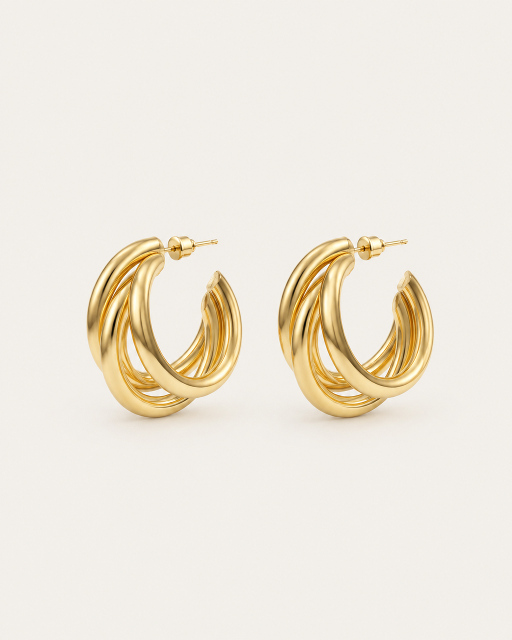 Pair of gold-tone hoop earrings with three overlapping strands, shown together.