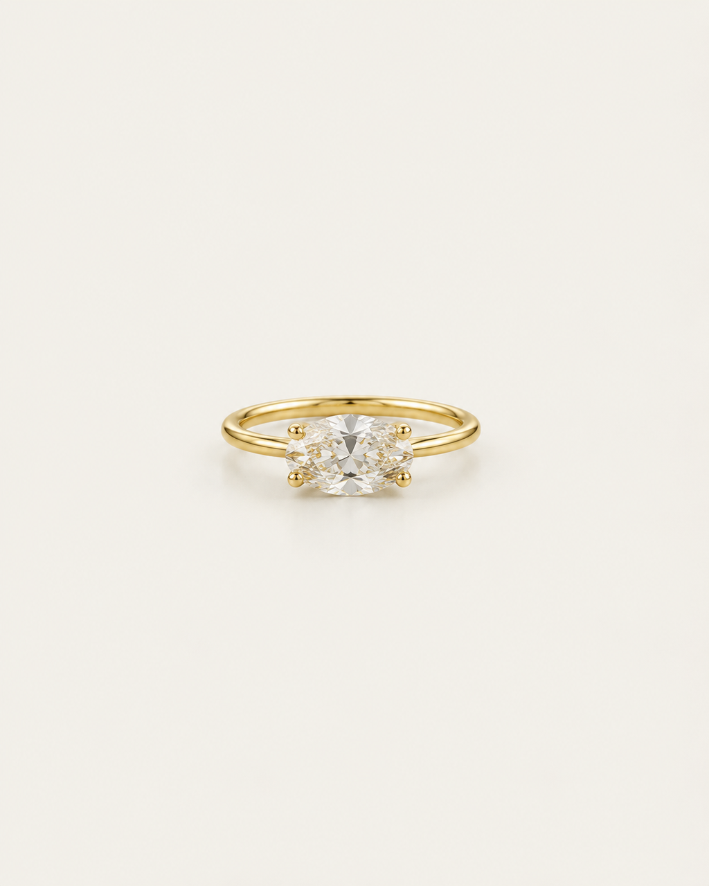 Gold-tone ring with a horizontal clear solitaire accent, shown on its own.