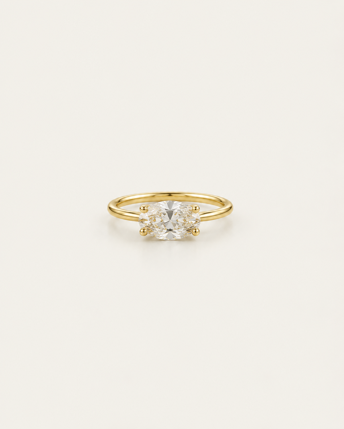 Gold-tone ring with a horizontal clear solitaire accent, shown on its own.