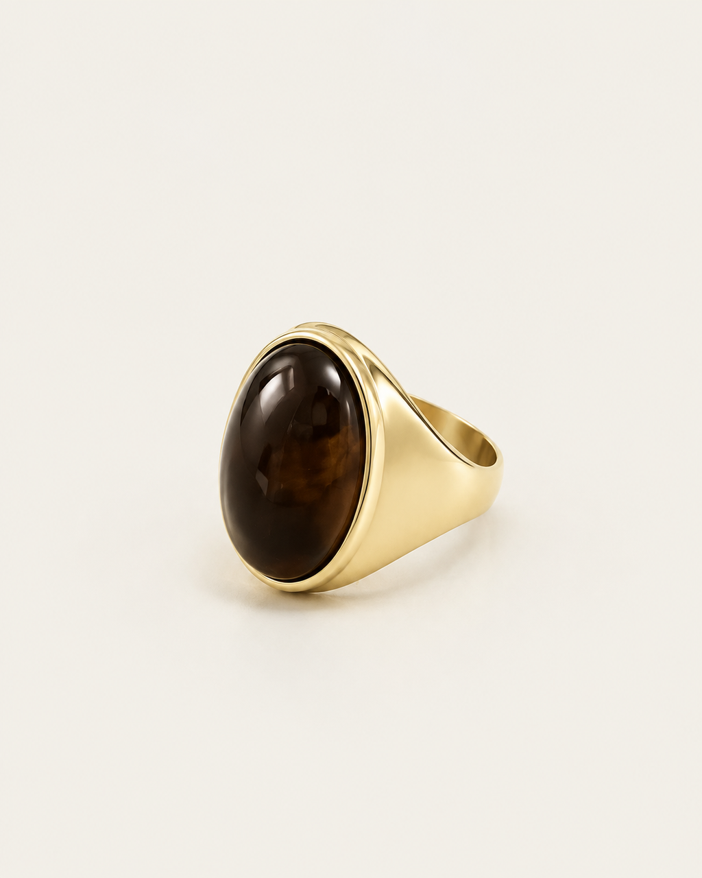 Gold-tone signet ring with a tall dark-brown oval accent, angled front view.