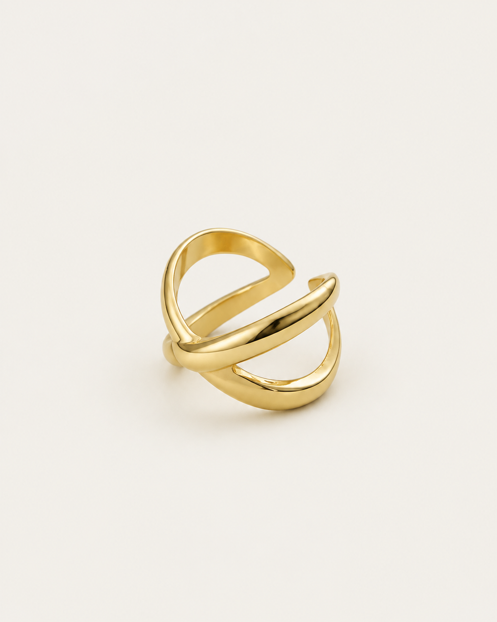 Gold-tone open ring with chunky crossover bands, angled view showing the intersecting bands.