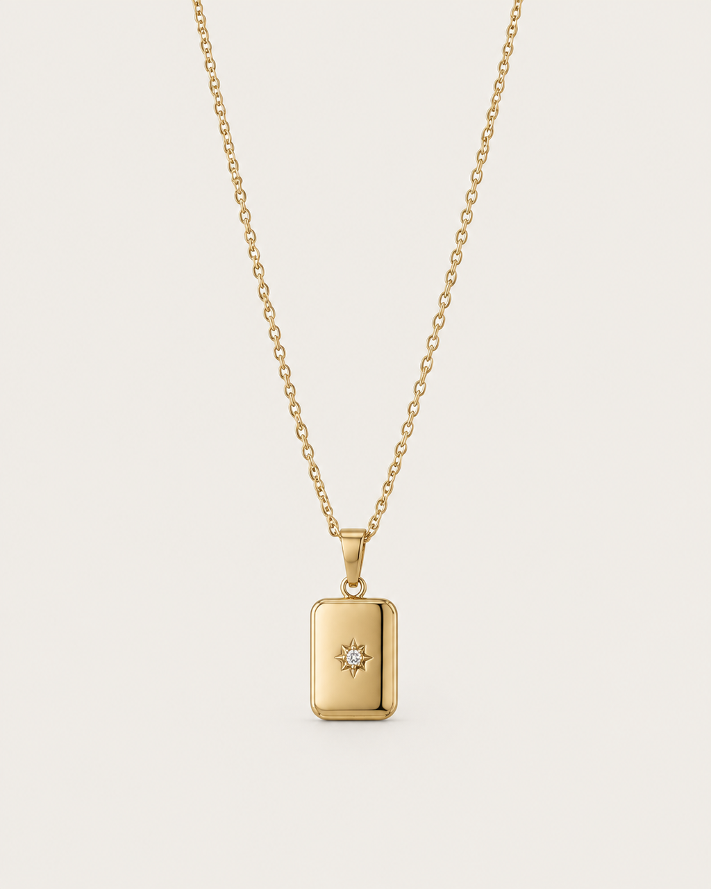 Gold-tone necklace with a rectangular celestial-motif tag pendant, front view.