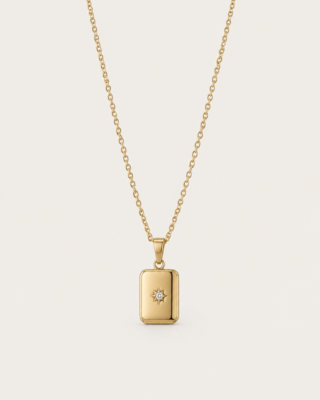 Gold-tone necklace with a rectangular celestial-motif tag pendant, front view.