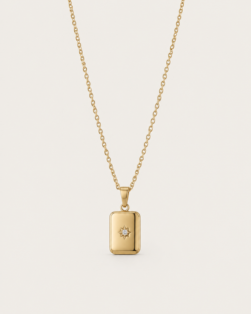 Gold-tone necklace with a rectangular celestial-motif tag pendant, front view.
