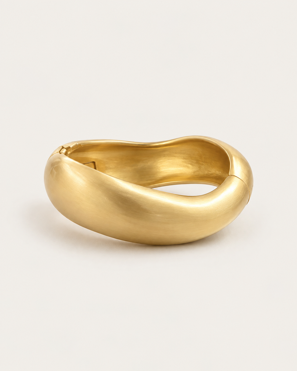 Gold-tone rounded contour bangle with a brushed-looking surface, front view.