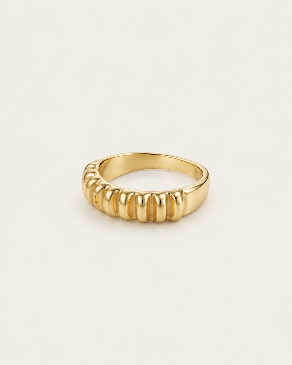 Gold-tone band ring with rounded vertical fluting, angled view showing the inner band.