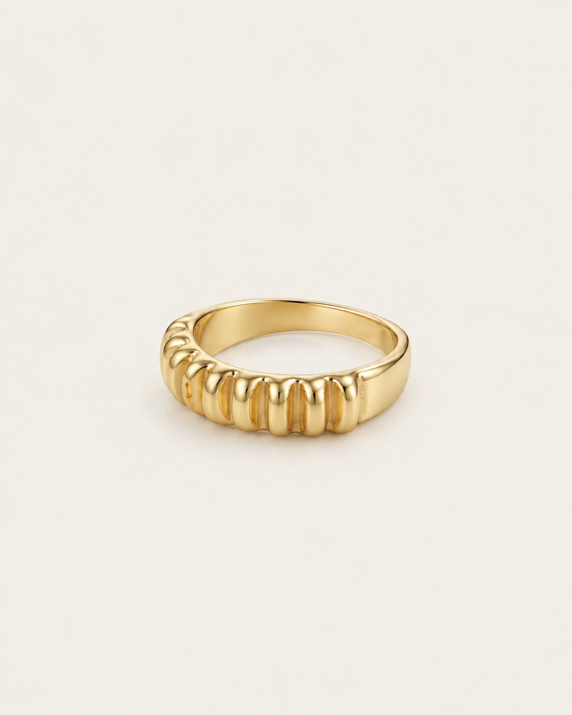 Gold-tone band ring with rounded vertical fluting, angled view showing the inner band.