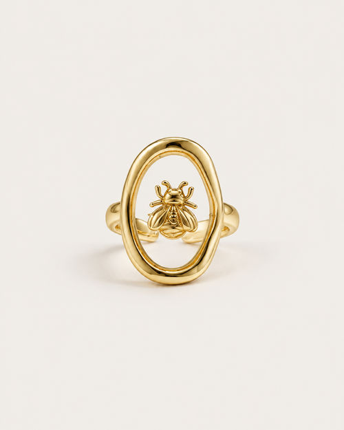 Gold-tone ring with a bee inside an open oval frame, front view.