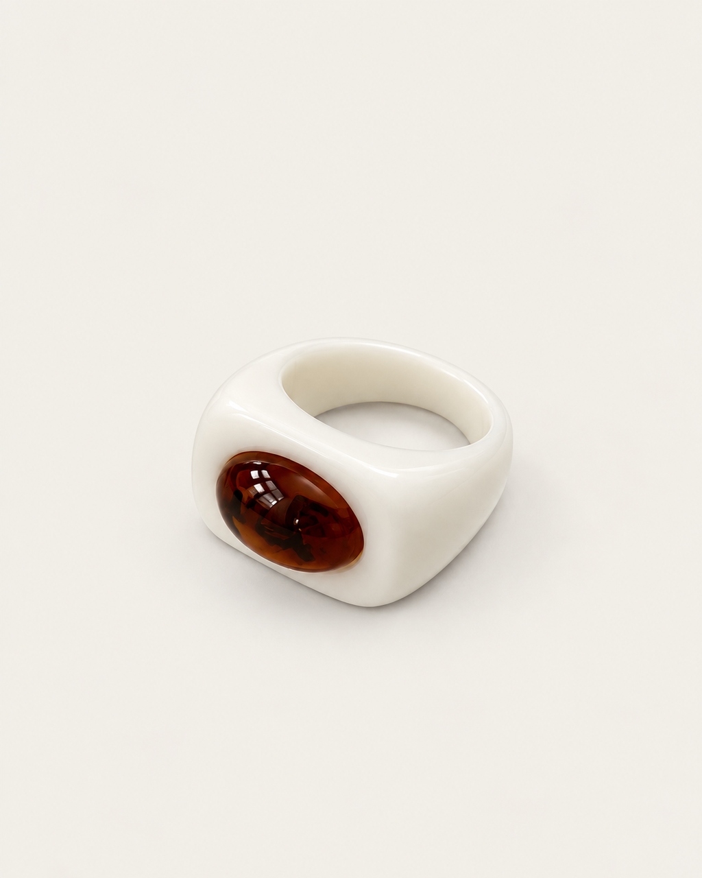 White ring with a contrasting brown oval accent, angled view showing the broad band.
