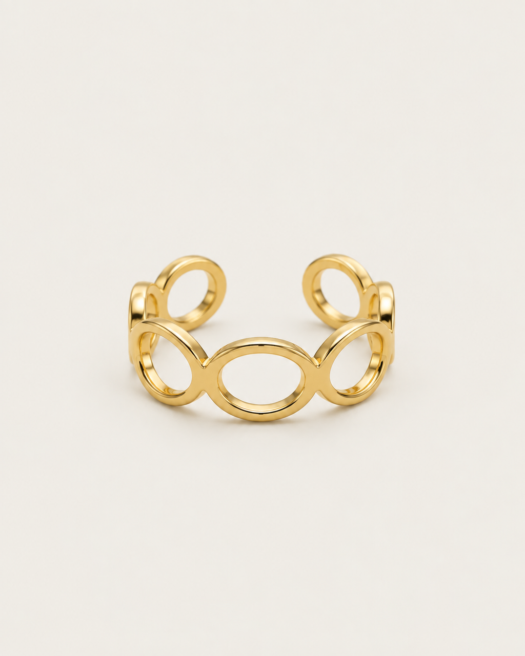 Gold-tone open band ring with linked geometric loops, front view.