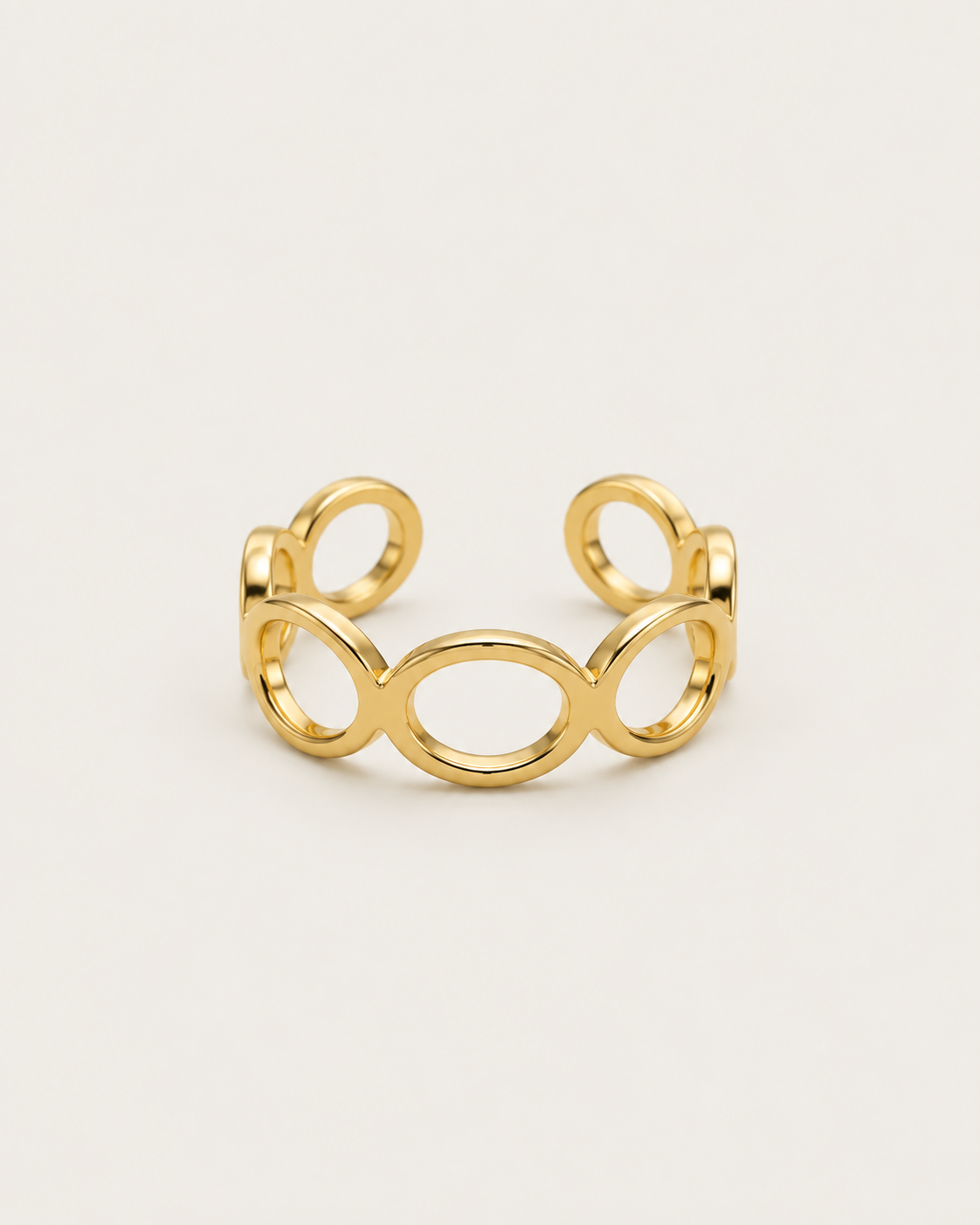 Gold-tone open band ring with linked geometric loops, front view.