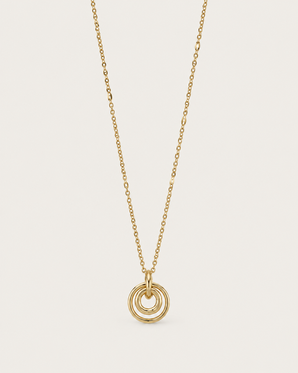 Gold-tone necklace with concentric circle pendants, front view.