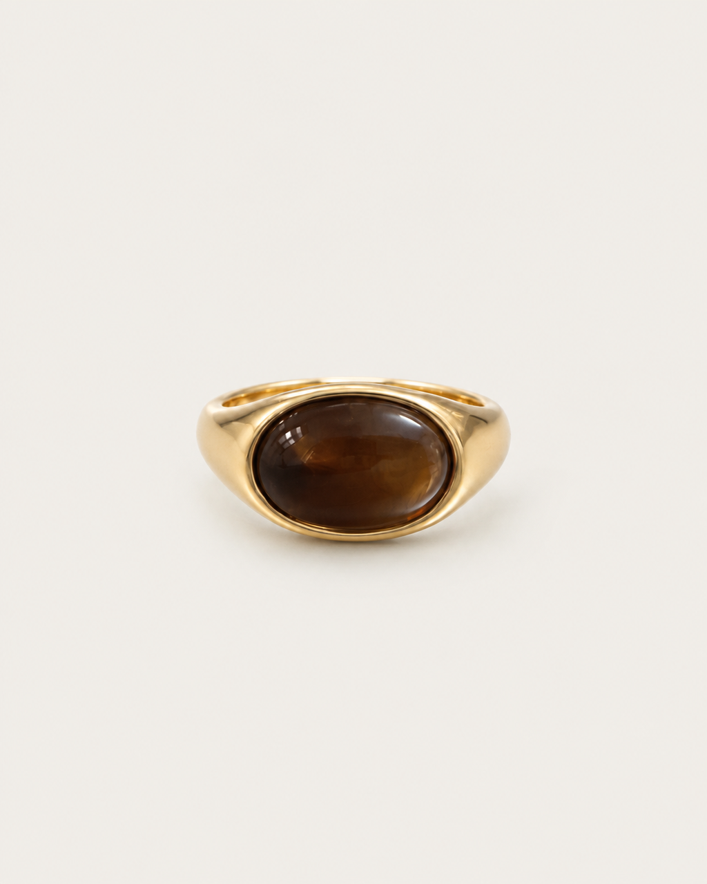 Gold-tone ring with a horizontal brown oval accent, front view.