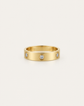 Gold-tone band ring with spaced round bezel-set stone accents, front view.