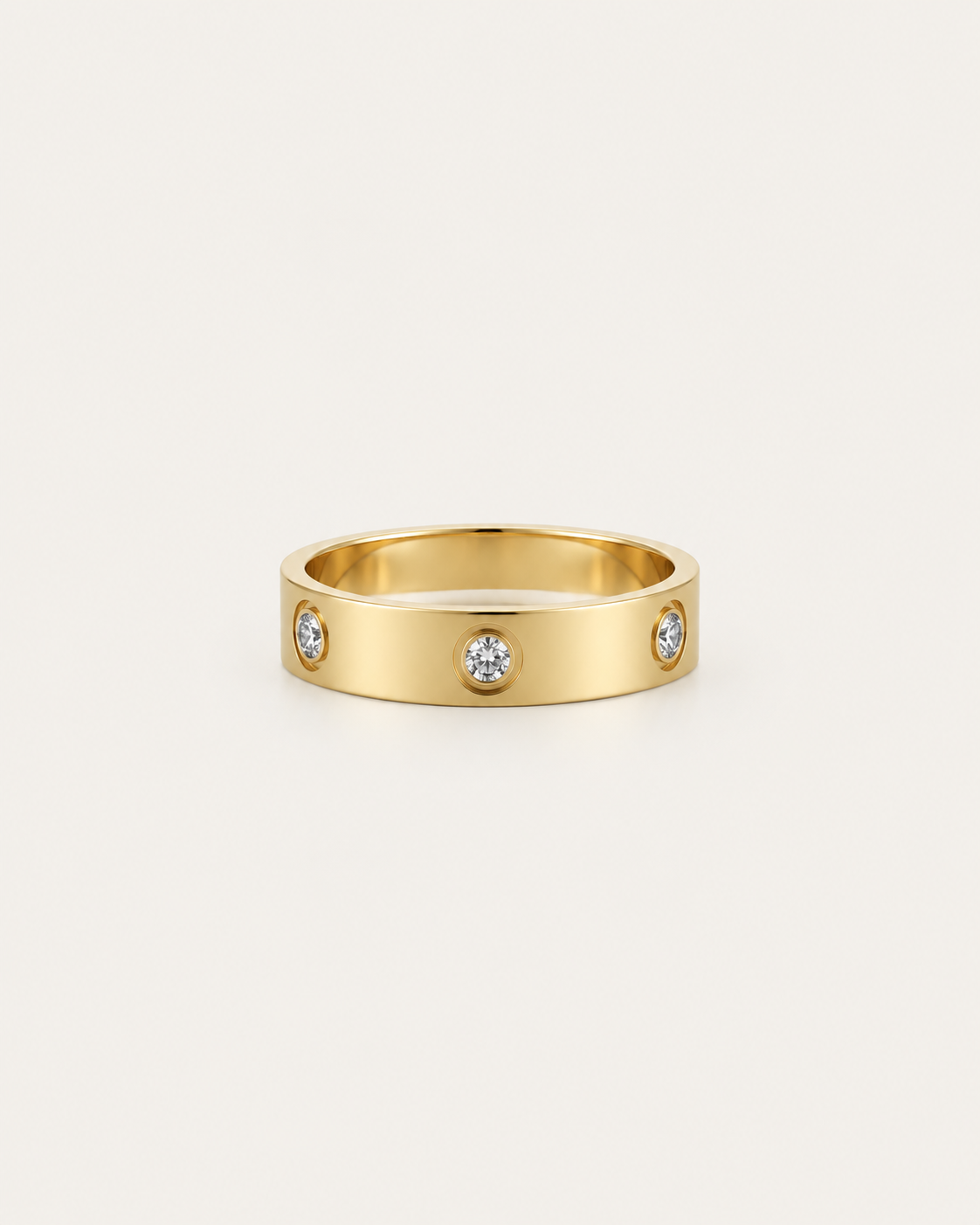 Gold-tone band ring with spaced round bezel-set stone accents, front view.