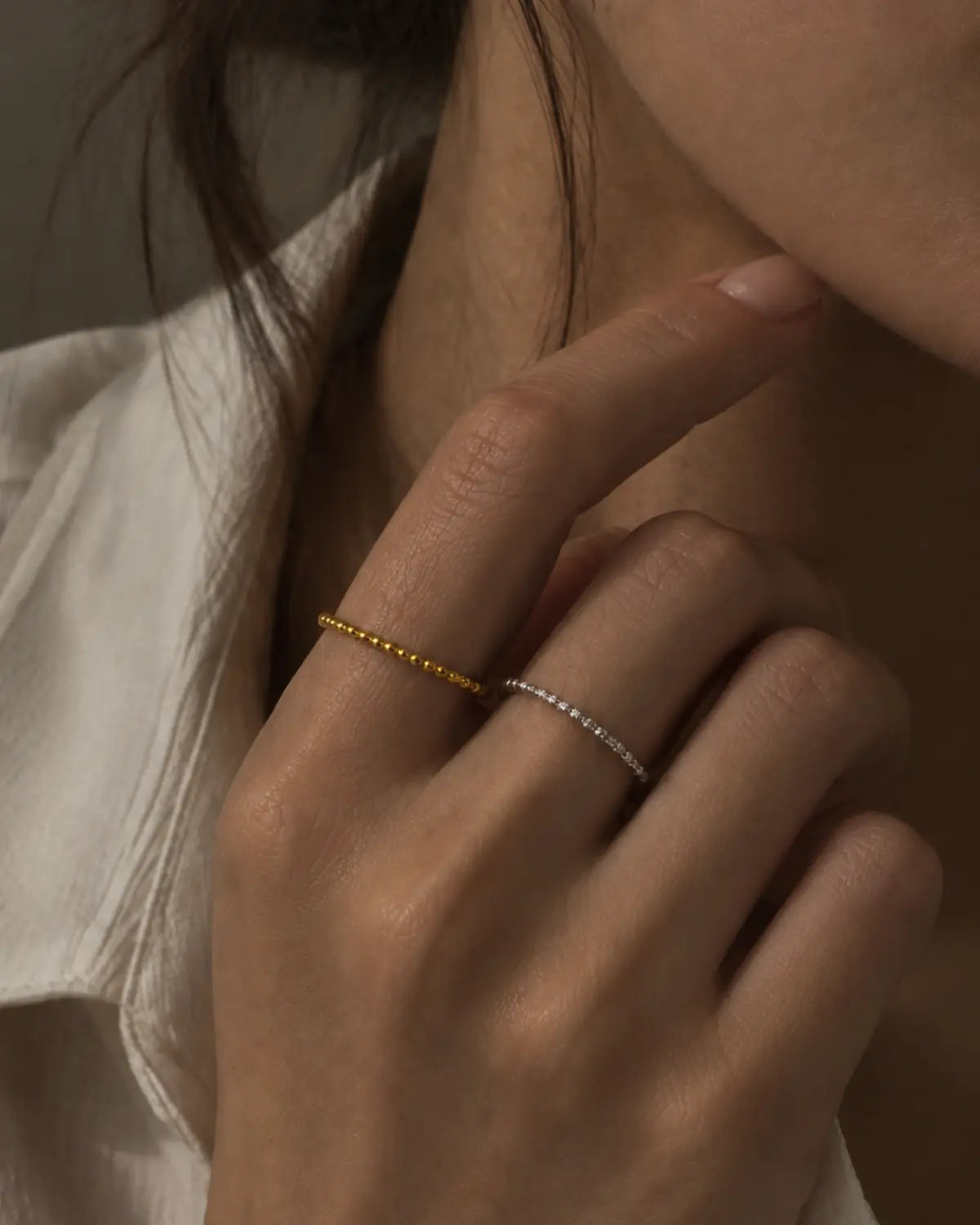 Gold-tone and silver-tone beaded rings worn on separate fingers in a styling comparison.