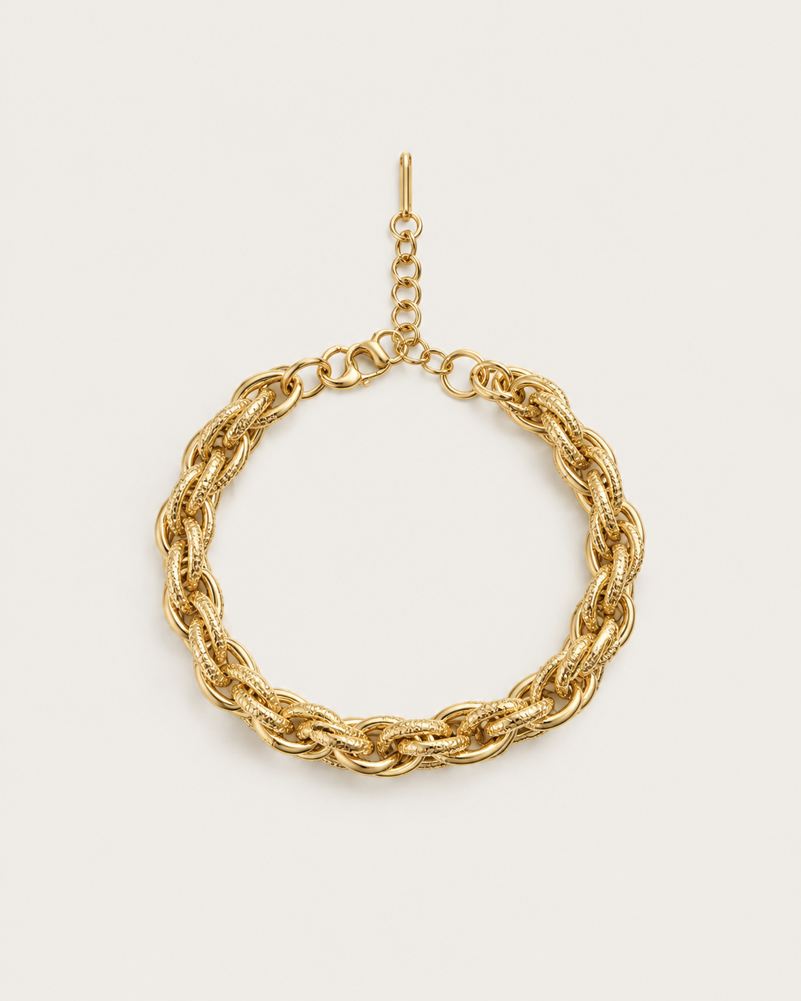 Gold-tone bracelet with chunky double links, laid out with an extension chain.