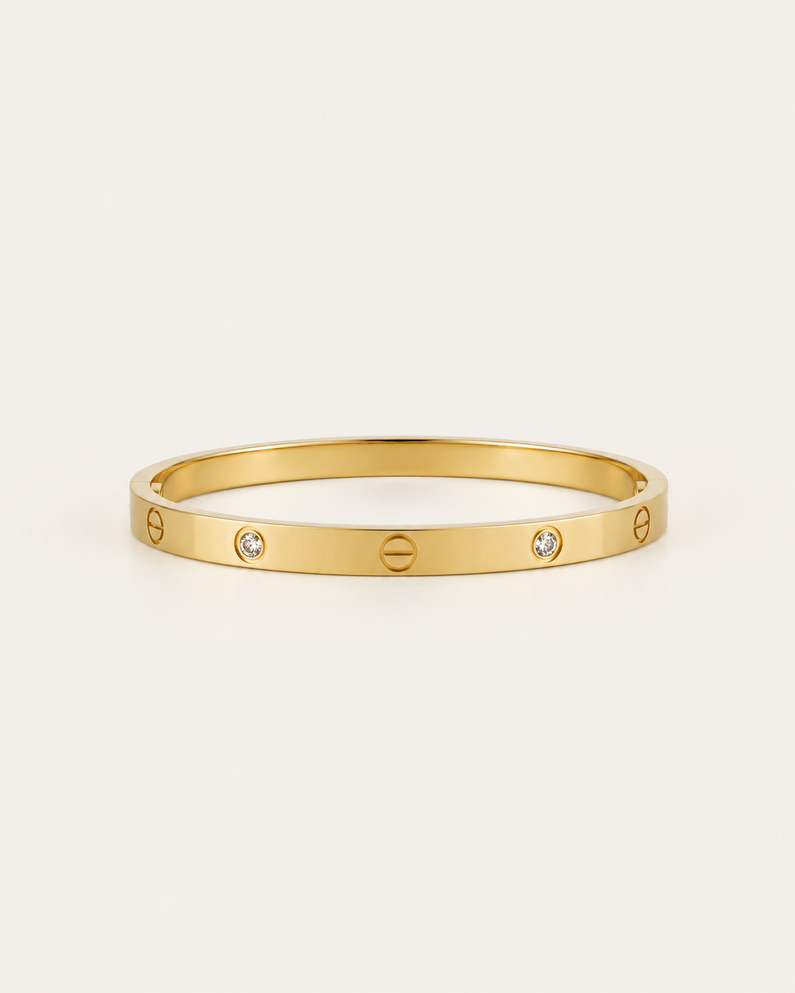Gold-tone bangle with screw motifs and alternating stone accents, front view.