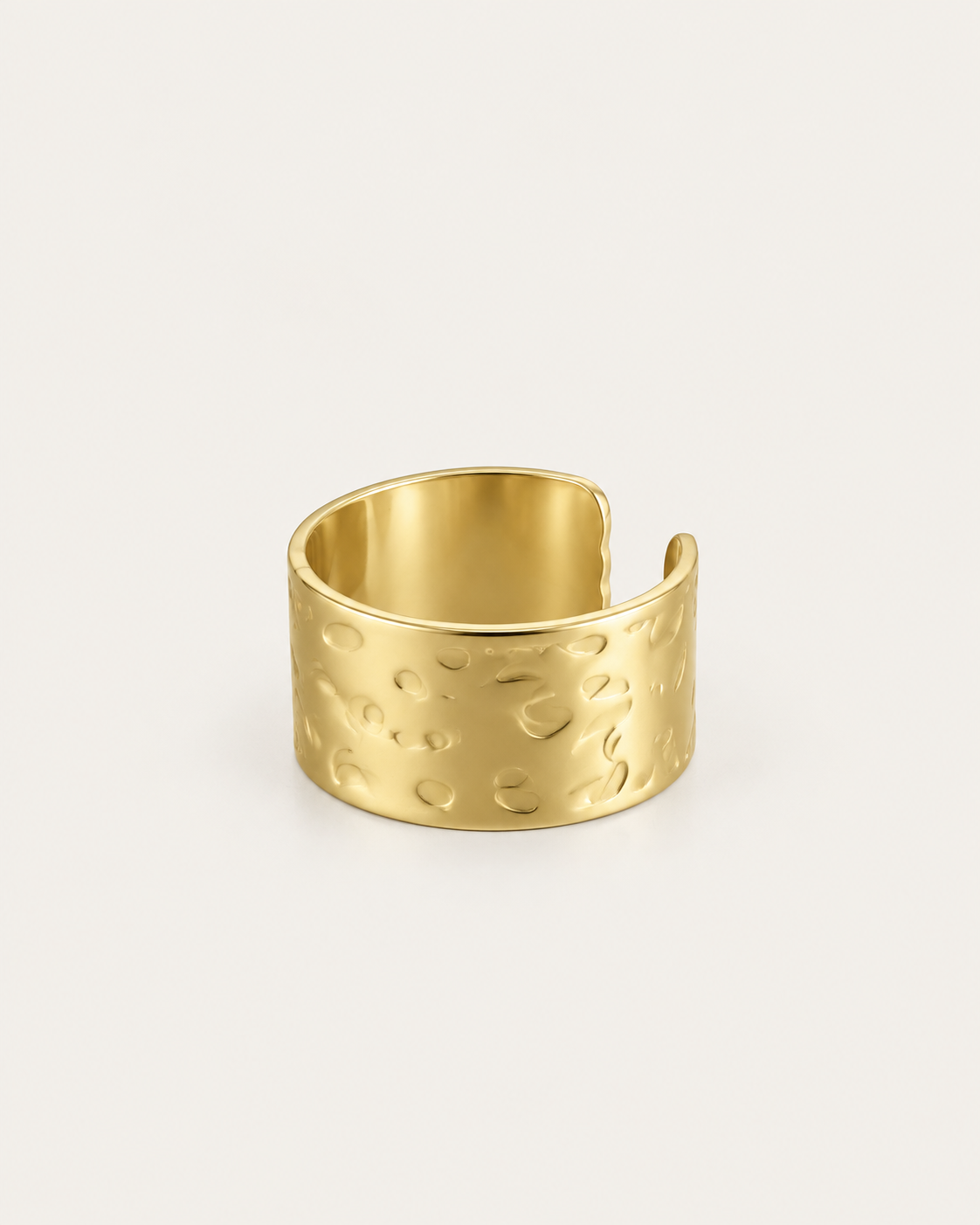 Wide gold-tone ring with a hammered surface, angled view of the open back and inner band.