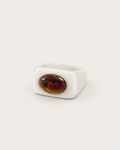 White ring with a contrasting brown oval accent, front view.