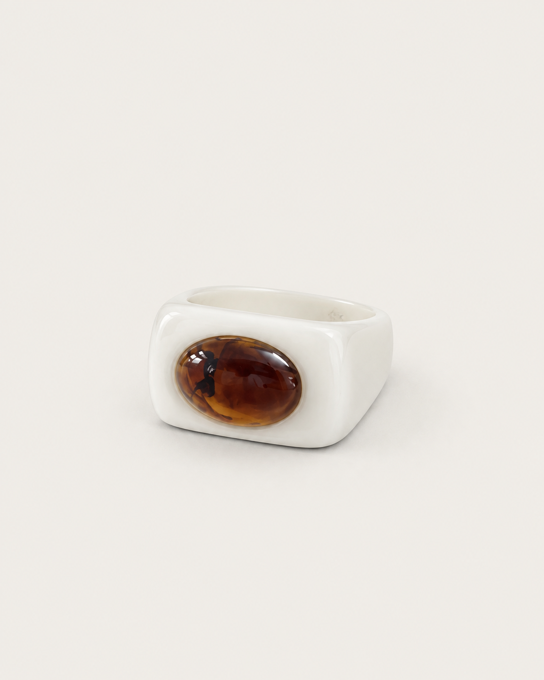 White ring with a contrasting brown oval accent, front view.