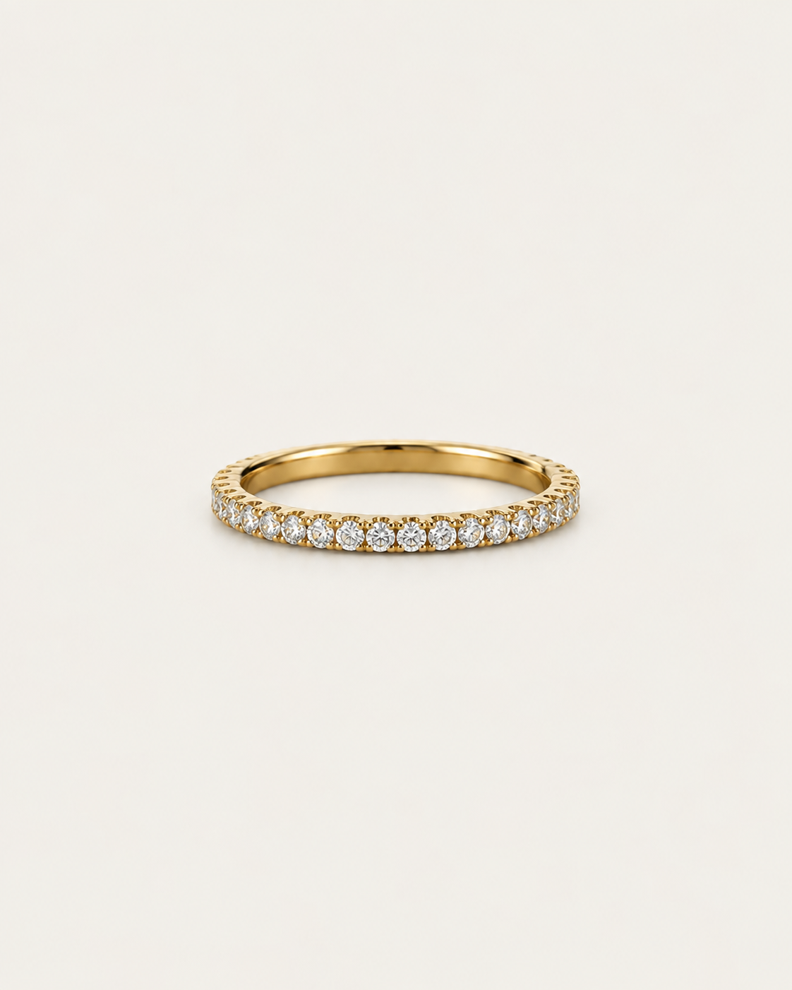 Gold-tone straight band ring with a row of pavé-style stone accents, front view.