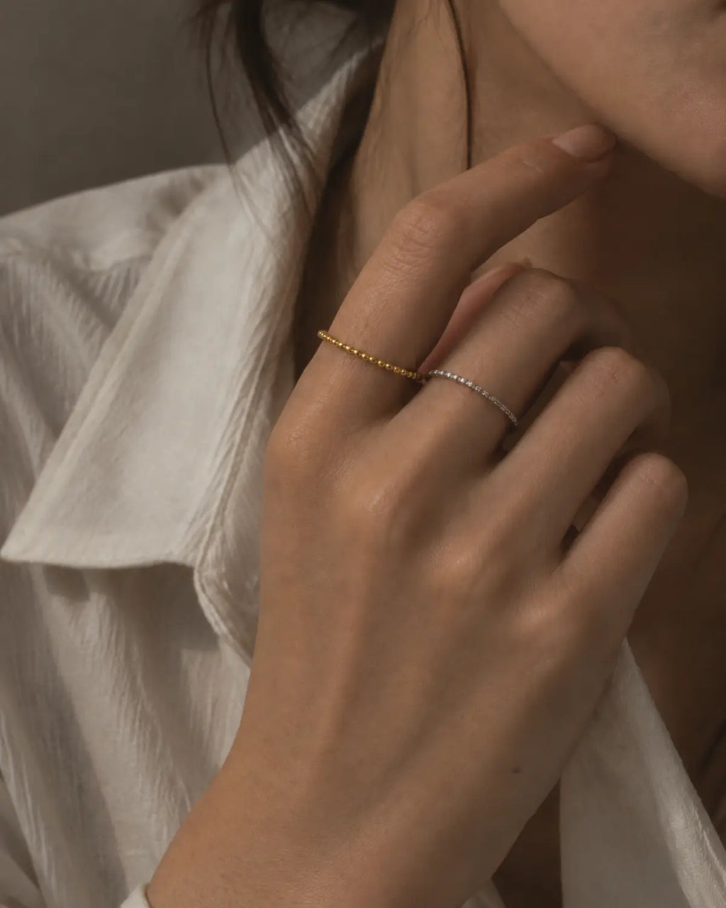 Silver-tone beaded band ring worn on a finger.