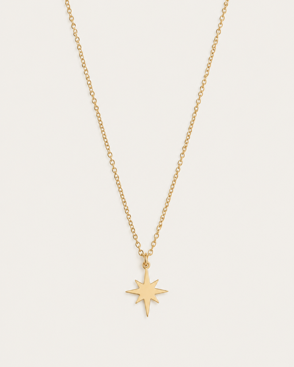 Gold-tone necklace with an eight-point star pendant, front view.