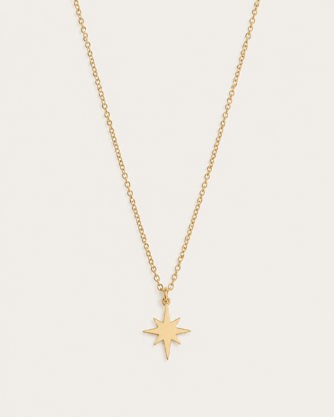 Gold-tone necklace with an eight-point star pendant, front view.
