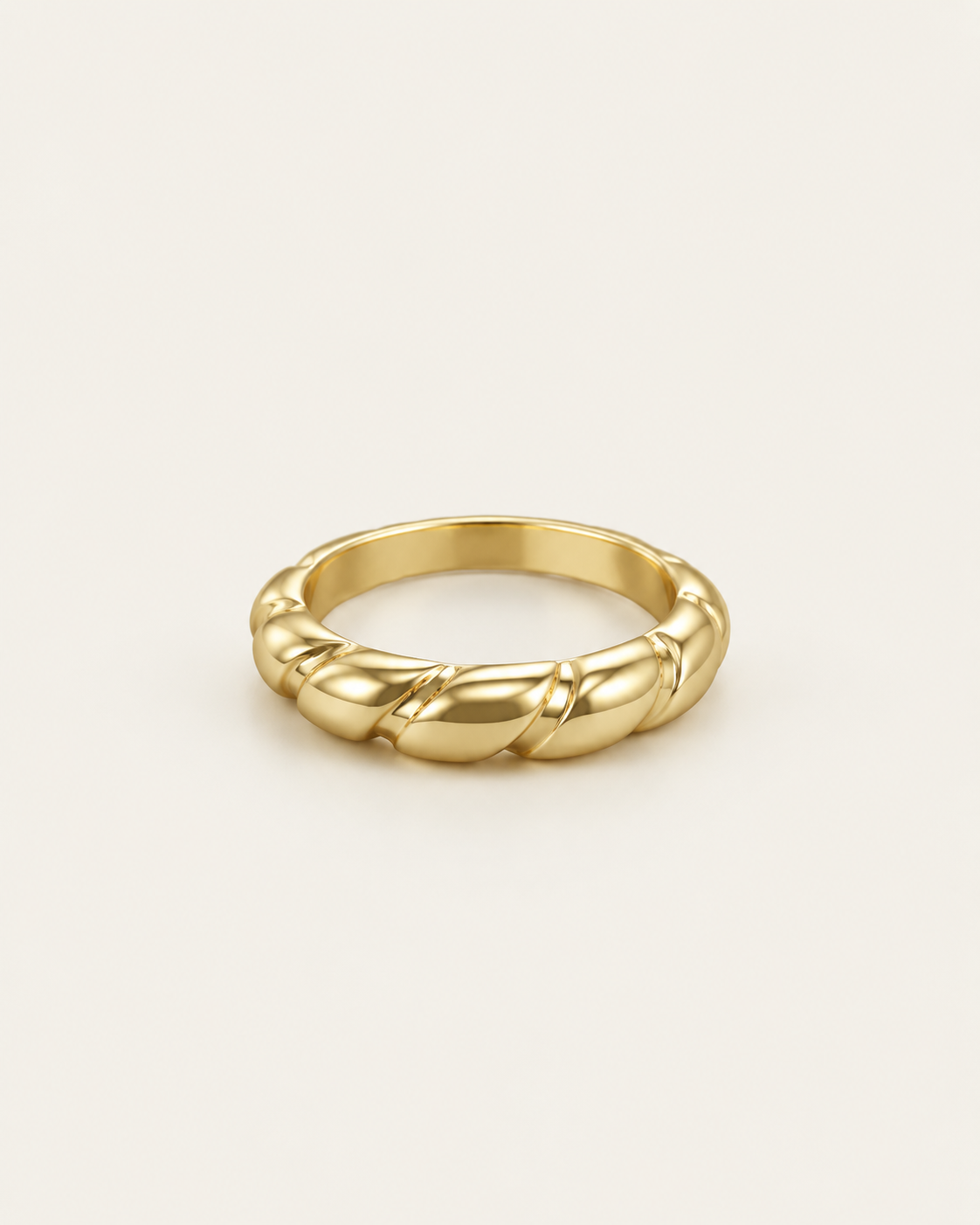 Gold-tone band ring with interwoven rounded twists, angled view showing the inside of the band.
